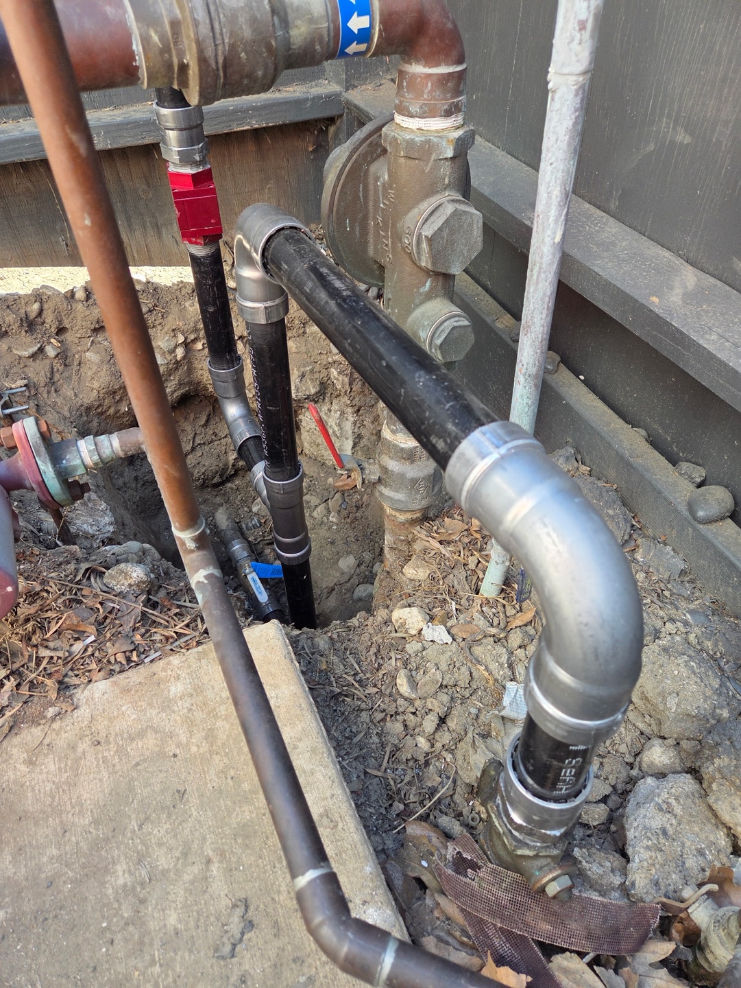 New underground water lines and shutoff valves in an open trench